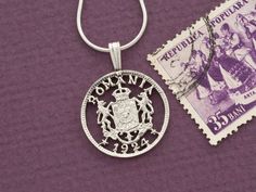 a stamp and a necklace on a purple background