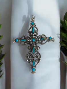 Discover the charm of history with our Vintage Ornate Filigree Cross Pendant. Featuring exquisite faux turquoise set in silver tone, this signed Roma piece is a true testament to Italian craftsmanship. Perfect for adding a touch of vintage elegance to any outfit, this unique pendant speaks of timeless beauty. Whether you're a collector or simply appreciate finely crafted jewelry, this statement piece from Italy is a must-have. Ideal for gifting or personal adornment, celebrate your style authentically with this stunning find. 2.5"x 2" Bohemian Turquoise Cross Jewelry, Bohemian Blue Cross Jewelry, Ornate Turquoise Jewelry For Collectors, Ornate Blue Nickel-free Jewelry, Ornate Nickel-free Blue Jewelry, Ornate Handmade Turquoise Jewelry, Ornate Turquoise Jewelry For Wedding, Handmade Silver Cross Turquoise Necklace, Ornate Turquoise Filigree Jewelry