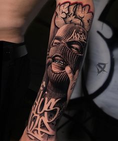 a man with a tattoo on his arm has a black and white image of a person's face