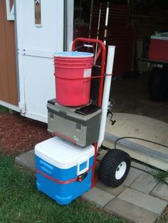 three coolers stacked on top of each other in front of a shed with wheels