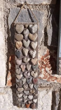 a stone wall hanging with hearts on it