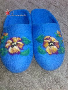 a pair of blue slippers with flowers painted on the inside and outside of them