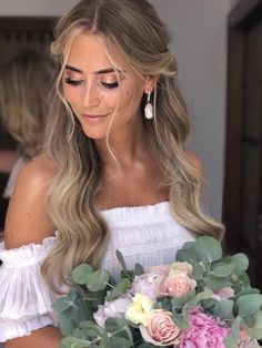 a woman holding a bouquet of flowers in her hands