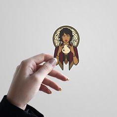 a person holding up a sticker with an image of a woman on it