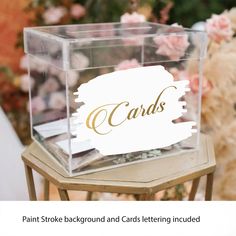 a clear acrylic box with cards on it sitting on top of a table