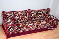 a red couch sitting on top of a hard wood floor