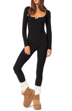 A stretchy ribbed design adds to the endless comfort of this cozy jumpsuit designed with long sleeves and a wide scoop neckline detailed with a dainty bow. Pull-on style Scoop neck Long sleeves 45% polyester, 45% rayon, 10% spandex Machine wash, dry flat Imported Winter Stretch Long Sleeve Unitard, Winter Long Sleeve Stretch Unitard, High Stretch Winter Unitard With Thumbholes, High Stretch Unitard With Thumbholes For Winter, Winter Long Sleeve Unitard With Thumbholes, Fitted Jumpsuits And Rompers With Thumbholes Long Sleeve, Casual Bodysuit With Thumbholes For Fall, Winter Ribbed Stretch Bodysuit, Casual Stretch Bodysuit For Winter