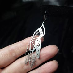 Stainless steel earrings shaped like hands full of Magick. Wing-shaped Pierced Earrings As Gift, Wing-shaped Earrings For Gift, Wing-shaped Pierced Earrings For Gift, Metal Symbolic Hypoallergenic Earrings, Symbolic Single Metal Earring, Stainless Steel Pierced Drop Earrings, Surgical Steel Drop Earrings As Gift, Surgical Steel Single Earring As Gift, Surgical Steel Drop Earrings For Gift