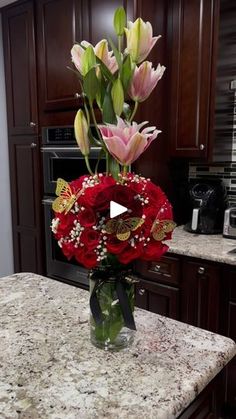 a vase filled with red flowers on top of a counter