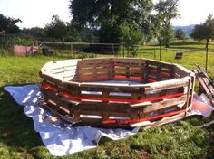 a large wooden bowl sitting on top of a blanket in the middle of a field