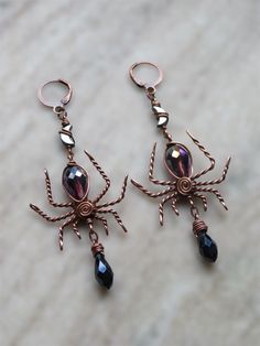 creepy, fancy spider earrings for the witch or lover of halloween season and creepy crawlies in your life!  made with solid, twisty antiqued copper wire, a faceted purple glass teardrop bead for the body, faceted dark navy blue glass briolettes hanging below  & lil hematite moons connecting the spiders to the hook✨ spider width is about 1.35" at widest part, drop length is about 2.5" and these are very lightweight for their size!  choose your hypoallergenic hooks :) Handmade Black Fantasy Earrings, Halloween Fantasy Earrings For Pierced Ears, Fantasy Halloween Earrings For Pierced Ears, Halloween Fantasy Dangle Earrings, Fantasy Dangle Earrings For Halloween, Handmade Vampire Jewelry For Halloween, Fantasy Halloween Dangle Earrings, Fantasy Metal Earrings For Halloween, Fantasy Earrings For Halloween Gift