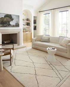 a living room filled with furniture and a fire place in front of a large window