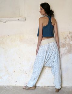 a woman leaning against a wall with her back to the camera