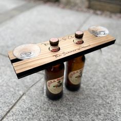 two beer bottles sitting on top of a wooden table