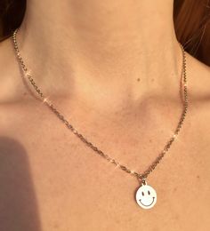 ♡ This shiny, unisex smiley necklace is made from pure stainless steel and is safe for showering and sensitive skin!! *:･♡ﾟ･ﾟ✧ ♡ Featuring a round smiley face pendant charm dangling from a thin, delicate chain! Very unique and cool while being easy to style & neutral / minimal ! *:･♡ﾟ･ﾟ✧ ♡ UP TO 20 INCHES LONG: 17 inch chain with a 3 inch chain extension for up 20 17 inches total wearable length ♡ This necklace is super unique and fun while still being versatile and easy to wear with anythin Happy Jin, Smiley Necklace, Smiley Face Necklace, Jewelry Layering, Face Pendant, Face Necklace, Goth Jewelry, Rave Festival, Layered Jewelry