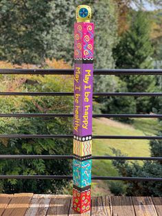 a tall colorful pole sitting on top of a wooden deck