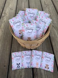 a basket filled with lots of cards sitting on top of a wooden table next to each other