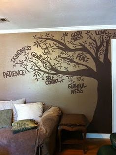 a living room with a tree painted on the wall