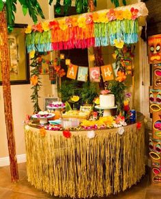 a table topped with lots of food and decorations next to two palm trees in the background