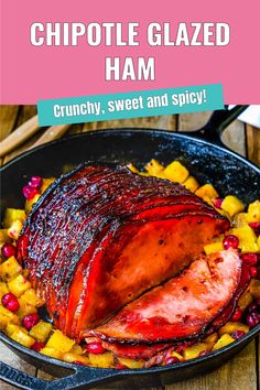 a ham in a skillet with pineapples and cranberries on the side