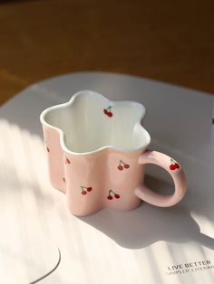 two pink cups sitting on top of a white table