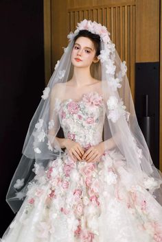 a woman in a wedding dress with flowers on the skirt, veil and headpiece