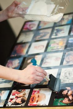 a table with many pictures on it being held by someone's hand and placing them into a plastic container