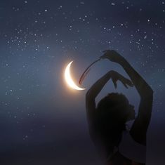 a woman holding her hands up in the air with a crescent moon and stars in the background