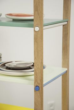 a wooden shelf with plates on top of it and another plate sitting on the bottom