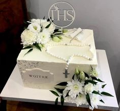 a white cake with flowers and a cross on top