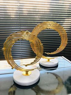 two gold and white circular sculptures sitting on top of a table