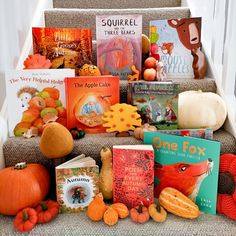 a bunch of books that are sitting on some kind of step rise with pumpkins and squash