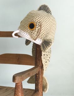 a crocheted fish hat sitting on top of a wooden chair