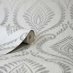 a roll of tape is laying on top of a wallpaper with an ornate design