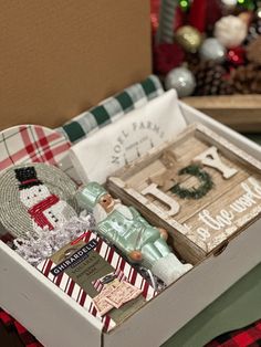 a box filled with assorted items on top of a table next to a christmas tree