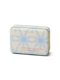 a white and blue tin with flowers on the front, sitting on a white surface