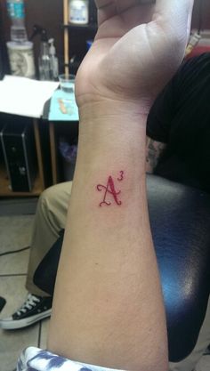 a person with a tattoo on their arm and the letter a in red ink is shown