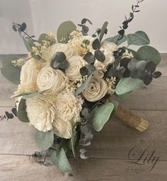 a bridal bouquet with white flowers and greenery