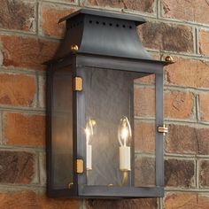 two lights are attached to a brick wall