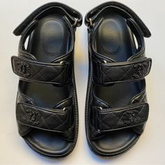 Chanel Dad Sandals In Black Quilted Lambskin With Cc Detail. This Was Bought May 2022 And Had Been Gently Worn Occasionally. Some Creases On The Leather Around The Sides. The Gold Foil Brand Stamp Has Been Erased From Use But You Could See Where It Was On The Insole. There Are Some Minor Scuffing At The Sole Edges As Seen On The Photos. I Had A Shoe Cobbler Install Rubber Soles At The Bottom When It Was Brand New. It Comes With Its Original Dust Bags, Care Card And Shoe Box. Size On The Box Is 3 Chanel Black Sandals, Black Calf Leather Sandals With Ankle Strap, Luxury Sandals With Leather Footbed And Ankle Strap, Designer Closed Toe Sandals With Leather Footbed, Luxury Ankle Strap Sandals With Leather Footbed, Black Calf Leather Sandals For Summer, Luxury Sandals With Leather Footbed, Luxury Black Sandals With Leather Sole, Designer Flat Leather Sandals