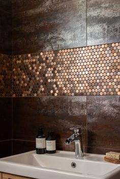 a bathroom sink sitting under a mirror next to a wooden cabinet with bottles on it