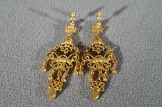 I am offering this fabulous vintage yellow gold tone pierced earrings. This piece is truly gorgeous, and it has the following features: * beautiful vintage earrings * yellow gold tone * chandelier style * faux amethyst * stud style * 2.5 inches in length This is a fantastic and classic piece. There is tons of sparkle and shine with this piece. It will beautifully complement your upcoming fashion season. Buyer pays all shipping and handling. Victorian Gold Plug Earrings, Ornate Dangle Chandelier Earrings For Formal Occasion, Formal Ornate Dangle Chandelier Earrings, Victorian Gold Filigree Chandelier Earrings, Victorian Gold Chandelier Earrings For Formal Occasions, Victorian Chandelier Dangle Earrings For Formal Occasions, Antique Gold Chandelier Earrings, Gold Costume Jewelry Earrings For Wedding, Ornate Bridal Earrings For Formal Occasions