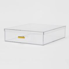 a clear box with a gold handle on the bottom and two drawers below it, sitting on a white surface