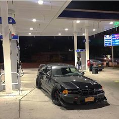 a black car is parked at a gas station