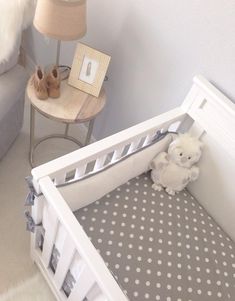 a baby crib with a teddy bear in it