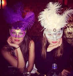 two women wearing masks sitting at a table