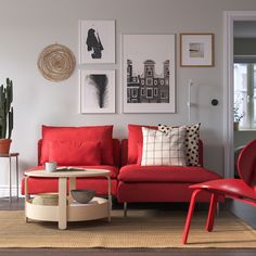 a living room with red furniture and pictures on the wall