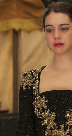 a woman in a black and gold dress