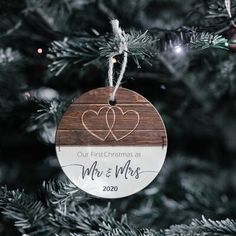 a wooden ornament hanging on a christmas tree with the words our first christmas as mr and mrs