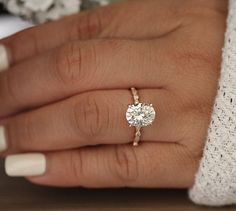 a close up of a person's hand with a diamond ring on their finger